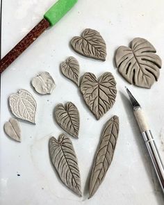 some clay hearts and a paintbrush on a table