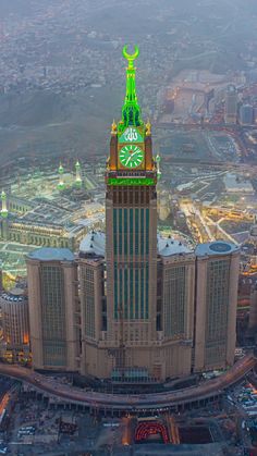 an aerial view of a large building with a clock on it's side and the surrounding city