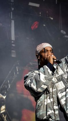 a man standing on top of a stage holding a microphone