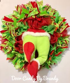 a christmas wreath with an elf's boot hanging on it