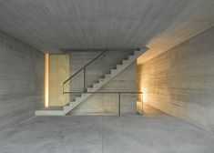 an empty room with concrete walls and stairs