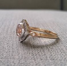 two gold and white diamond rings sitting on top of a table