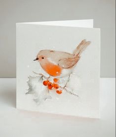 a card with a bird sitting on top of a leafy branch and orange berries