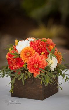 an orange and white flower arrangement in a wooden box with the words, don't waste un dummeeze