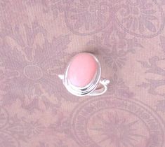 "Gorgeous pink Opal on a solid 925 sterling silver setting. Colorful, romantic, delicate rings.  Measures approx. 3/4\" x .52\" x 1/4\" H  Light pink and rose-pink tones of genuine Opal for you to choose your favorite.  Rose Pink is just a little darker.    * Made of genuine gems and color variations may occur but are all gorgeous!" Pink Moonstone Sterling Silver Ring For Anniversary, Pink Sterling Silver Moonstone Promise Ring, Pink Oval Ring With Bezel Setting, Oval Pink Ring With Bezel Setting, Pink Adjustable Ring For Formal Occasions, Pink Adjustable Formal Rings, Formal Adjustable Pink Rings, Fine Jewelry Pink Cabochon Ring, Pink Cabochon Jewelry For Anniversary