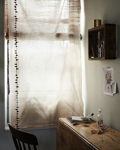 a chair sitting in front of a window next to a wooden desk