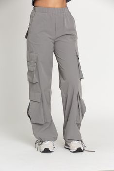 NEW Limited Edition & custom designed Dusty Grey Parachute Pants! Not only did we spend months designing these amazing cargo style pants, but we PERFECTED them in the process! These pants are insanely versatile due to their lightweight material and trendy style. They feature adjustable ankle cuffs that you can leave wide or tie up for a jogger look. The elastic waist-band allows for a comfortable fit and the multiple pockets provide great functionality. These pants easily can be worn for any wor Gray Full-length Cargo Pants With Cargo Pockets, Gray Full Length Cargo Pants, Fitted Utility Cargo Parachute Pants, Fitted Nylon Parachute Pants With Cargo Pockets, Fitted Full Length Cargo Parachute Pants, Trendy Gray Parachute Pants With Cargo Pockets, Fitted Cargo Pants For Outdoor, Trendy Nylon Pants With Cargo Pockets, Fitted Cargo Pants With Pockets For Outdoor