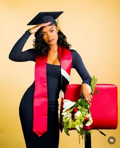 a woman wearing a graduation gown and holding a bouquet of flowers in front of her head