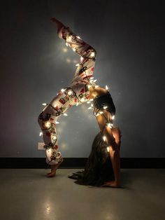 a woman is standing in the middle of a dance pose with lights all around her