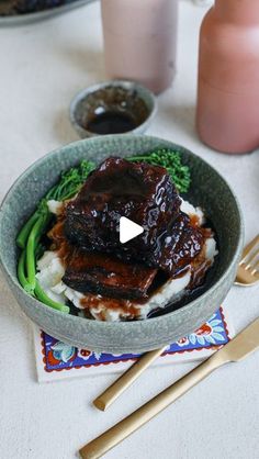 a bowl filled with meat, mashed potatoes and broccoli on top of a table