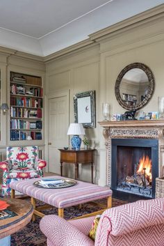 a living room filled with furniture and a fire place in the middle of a room