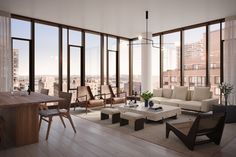 a living room filled with furniture and large windows overlooking the cityscape in the distance