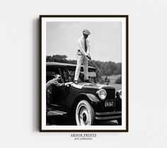 an old black and white photo of a man on top of a car