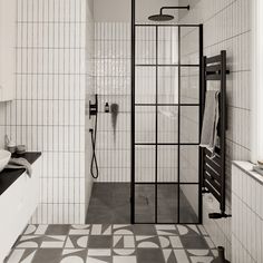 a black and white photo of a bathroom with tiled walls, flooring and shower