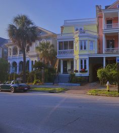 a row of multi - colored houses on the corner of a street