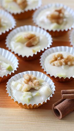 several cupcakes with white frosting and nuts on top