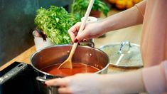 a person stirring something in a pot on the stove