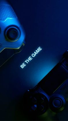 a video game controller sitting on top of a table next to a blue remote control