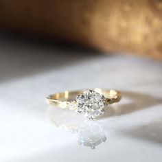 a diamond ring sitting on top of a white surface with the light shining through it