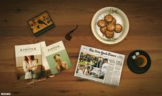 a table topped with magazines and food next to a cup of coffee