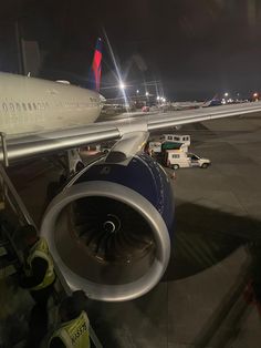 an airplane parked on the tarmac at night with its engine still attached to it