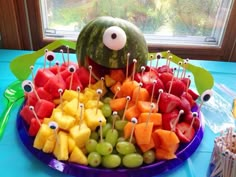 a platter filled with fruit and eyeballs on top of a blue table cloth