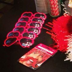 the party table is decorated with red and white streamers, sunglasses, candy canes, and cake