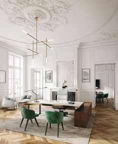 an elegant living room with white walls and wood flooring is furnished with green velvet chairs