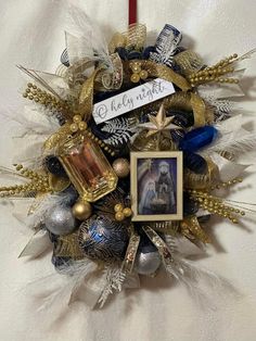 a christmas wreath with an ornament hanging from it's side and a candle in the middle