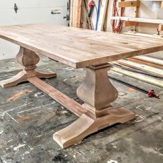 a large wooden table sitting on top of a floor next to some wood planks