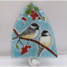 two birds sitting on a branch with berries and leaves painted on it's side