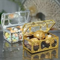 an open gold box filled with chocolates on top of a table next to other candies