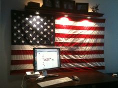 an american flag is hanging on the wall behind a computer desk with a keyboard and mouse