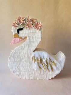 a paper mache sculpture of a swan with flowers on it's head and neck