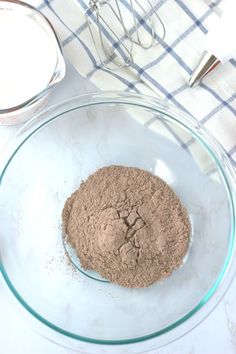 a glass bowl filled with dry ingredients on top of a table