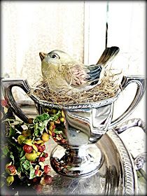 a bird sitting on top of a silver cup filled with food