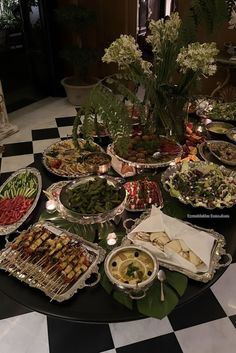 a table filled with lots of food on top of a checkered floor