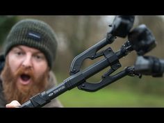 a man with a beard is holding an outdoor device in his hand and looking at the camera