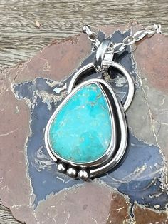 "Gorgeous Campitos Turquoise pendant.   This stone is such a lovely soft blue shade and I love the larger teardrop shape.  In person you will see soft golden matrix, but from a distance it is just a soft, glorious blue.   We kept the setting simple to highlight this beautiful stone, just a simple wire to show off the stone and some silver balls to accent it.  The setting is fine and sterling silver.   It has been finished with a soft patina to bring out the setting's details.  All photos were taken outside in indirect lighting.  This would be a great gift for you or someone you love!  Pendant comes on your choice of an 18\",  20\" or 24\" sterling silver 2.8 mm rolo style chain (pictured) - which can be hooked at any point to make it shorter.  In the photos it is shown on the 24\" chain at Turquoise Teardrop Gemstone Pendant Jewelry, Blue Cabochon Drop Jewelry, Blue Drop Cabochon Jewelry, Blue Drop Jewelry With Cabochon, Turquoise Teardrop Necklace In Southwestern Style, Turquoise Teardrop Pendant With Large Stone, Handmade Artisan Turquoise Teardrop Necklace, Turquoise Teardrop Pendant Jewelry, Artisan Handmade Teardrop Turquoise Necklace