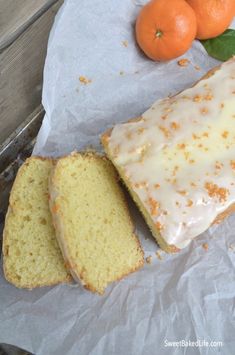 there is a loaf of cake and two oranges on the table