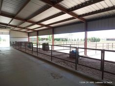 the inside of a horse barn with stalls and horses in pens on either side of the fence