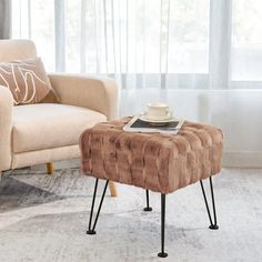 a living room scene with focus on the chair and footstool in the foreground