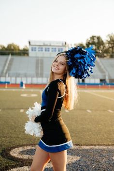 a cheerleader is walking on the field with her pom poms in hand