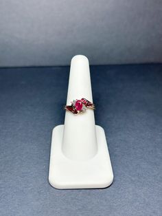 10K Yellow Gold Bypass Ruby Ring w/ Diamond Accents - Size 7  This is a beautiful ladies ring featuring a center ruby oval with square cut rubies in a bypass setting and diamond accents. This ring measures 0.7 mm in length and 0.4 mm in height. The weight is 2.2 grams. Estate Jewelry #B354 Shipping Free shipping in the United States. No international shipping. We ship all items within 1-3 business days. Returns We offer a 30-day return policy About Us Here at Direct Jewelry Niles, we offer Exclusive, Affordable Elegance delivered to you with superior customer service and excellent prices. Oval Multi-stone Ruby Ring In Yellow Gold, Oval Ruby Ring Stamped 14k, Oval Ruby Cluster Ring Stamped 14k, 14k Gold Multi-stone Oval Ruby Ring, Oval Multi-stone Ruby Ring In 14k Gold, 14k Gold Multi-stone Ruby Ring, Gold Marquise-cut Ruby Jewelry, Classic Ruby Jewelry With Marquise Cut, Gold Ruby Marquise Cut Jewelry