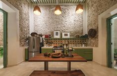 a kitchen area with a table, oven and refrigerator in it's centerpiece