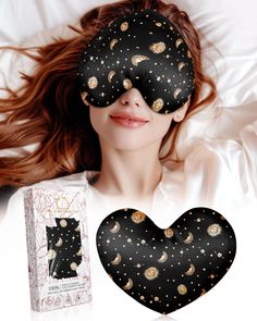 a woman laying on top of a bed next to a black heart shaped eye mask