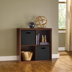 a shelf with three bins on top of it in the corner of a room