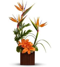 an orange flower arrangement in a wooden vase