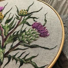 a close up of a embroidery on a piece of cloth with flowers in the middle