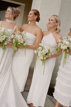 the bridesmaids are all wearing white dresses and holding bouquets in their hands